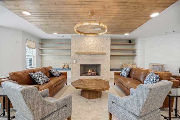 a living room with couches and chairs and a fireplace at Oak Grove at Blake Farm, 28411