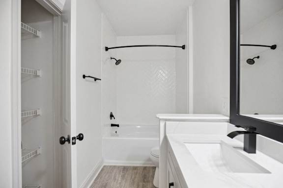 A white bathroom with a walk in shower and a white bathtub.