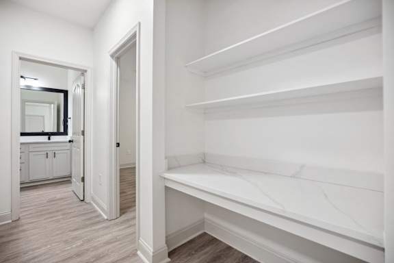 A white hallway with a mirror and a bench.