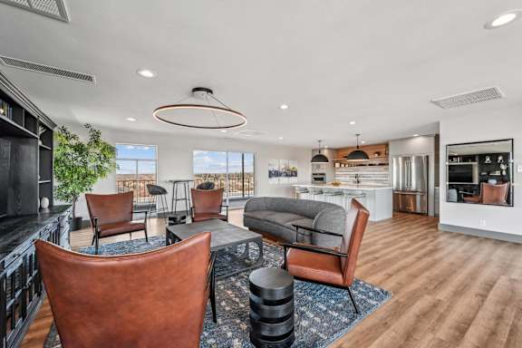 A modern living room with a brown leather chair in the foreground. at The Lex At Lowry, Denver, Colorado