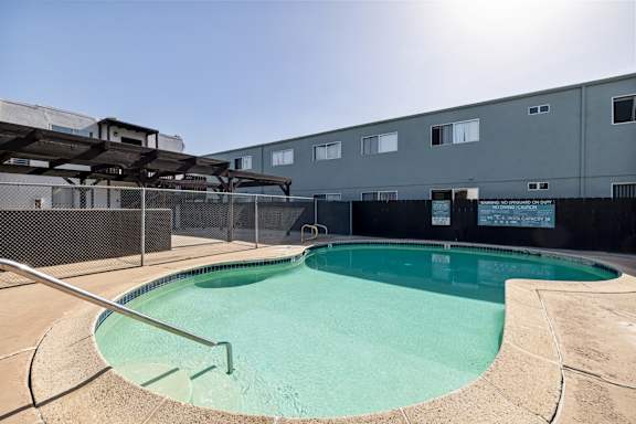 A small pool with a metal fence around it.
