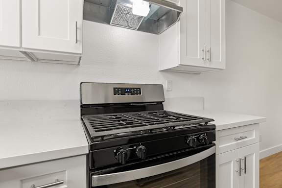 A modern kitchen with a black stove top oven.