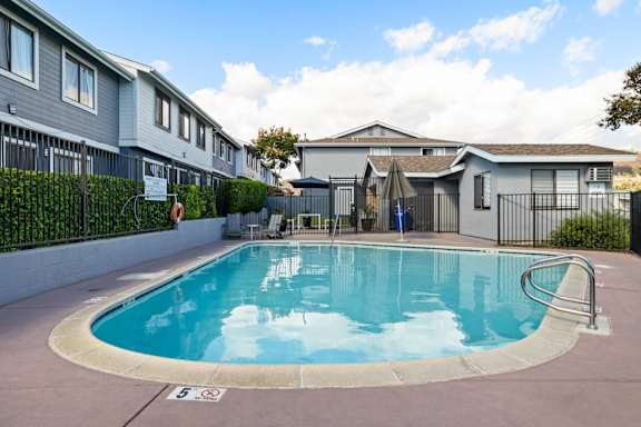A swimming pool in a residential area with a sign that says "5".