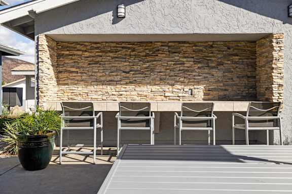 A patio with a table and chairs is set up outside a house.