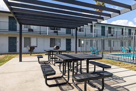 A black table and benches are set up under a black awning.