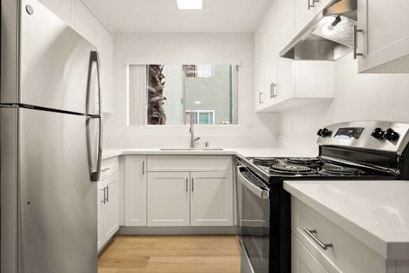A modern kitchen with white cabinets and stainless steel appliances.