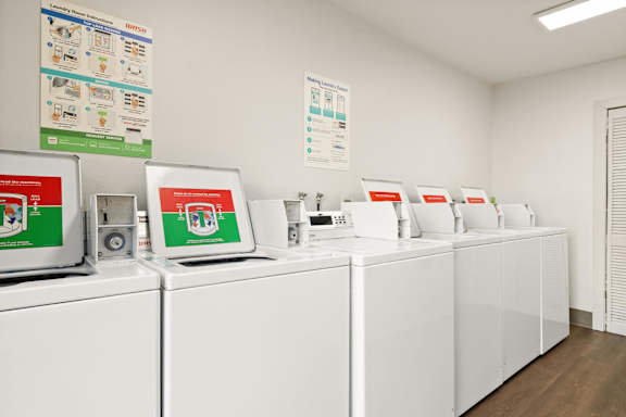 A row of washing machines are lined up in a laundromat.