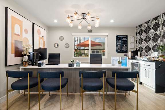 A modern kitchen with a bar area and chairs.