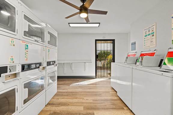 A row of white ovens are lined up in a kitchen.