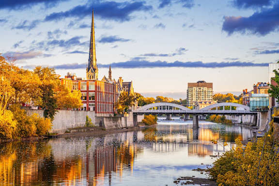 A cityscape with buildings of various heights and architectural styles under a sky with a gradient of colors.