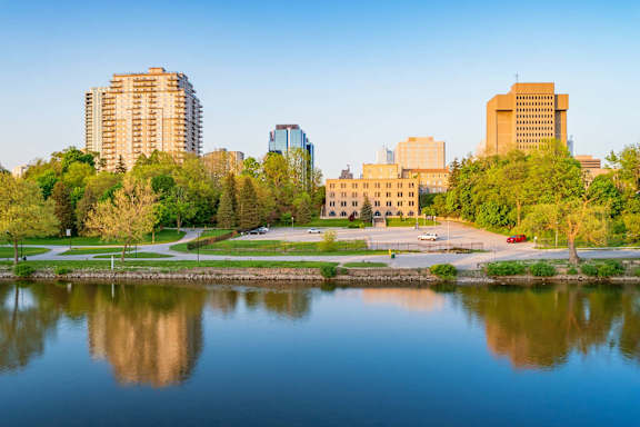 A cityscape with buildings of various heights and architectural styles under a sky with a gradient of colors.