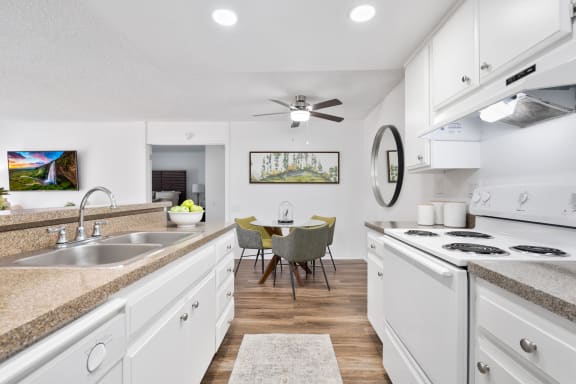 a kitchen and dining room with white cabinets and white appliances