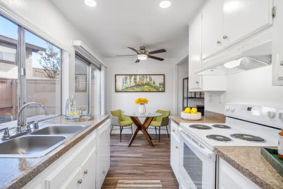 a kitchen with white cabinets and a counter top and a sink