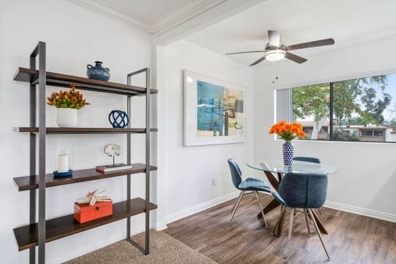 a dining room with a table and chairs and a ceiling fan