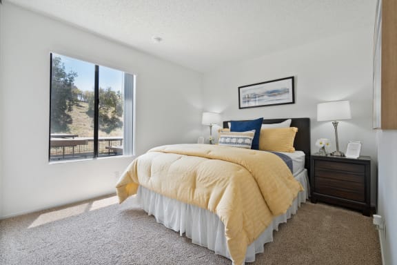 a bedroom with a bed and a large window