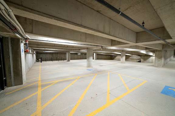 A parking garage with yellow lines on the ground.