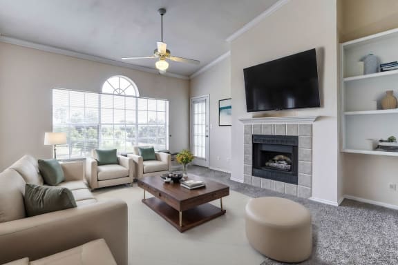 Light and bright living rooms with built in book shelves, large windows and fireplaces at Turnberry Isle Apartments in Dallas, TX.