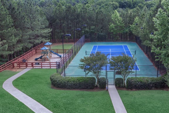 an aerial view of a tennis court with trees in the background