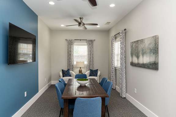 A dining room with a wooden table and blue chairs.