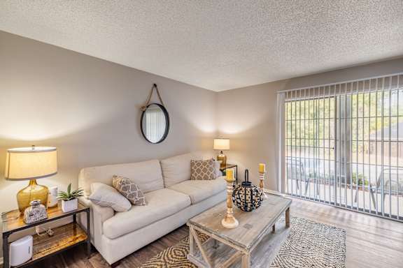 a living room with a white couch and a glass coffee table