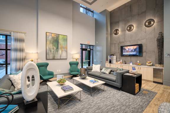 A living room with a brown sofa, a black coffee table, and a television.