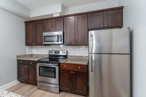 A kitchen with a stainless steel refrigerator, oven, and microwave.