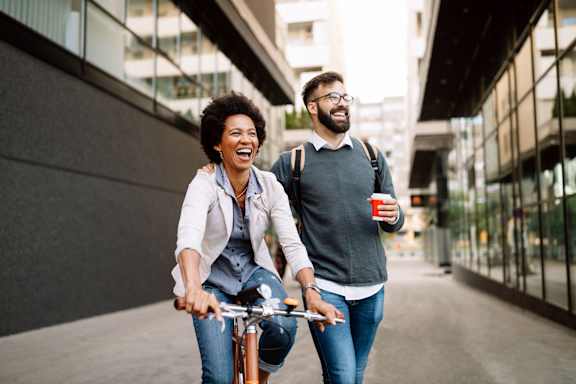 A man and a woman are riding a bicycle together.