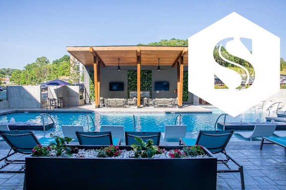a swimming pool with blue chairs and a pool house with a graphic at Sterling Nashville West Apartments, Nashville, 37209