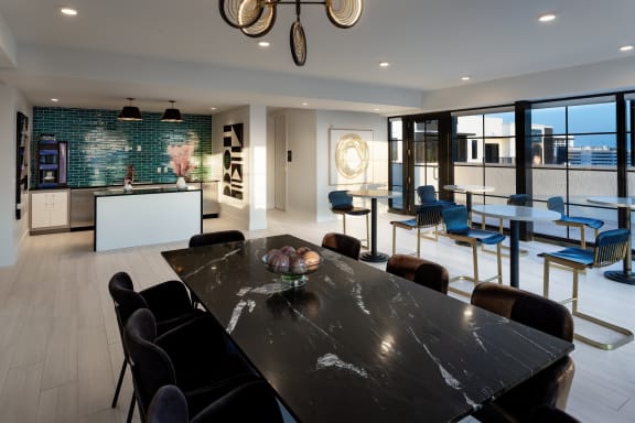 a large dining room with a black dining table and black chairs