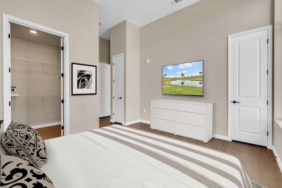 A bedroom with a large bed and a television on a cabinet.