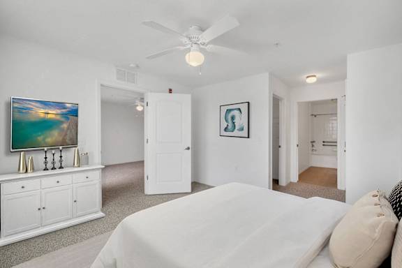 A bedroom with a large bed and a painting on the wall.