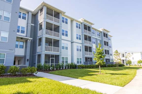 Apartment complex with a tree in the front yard.