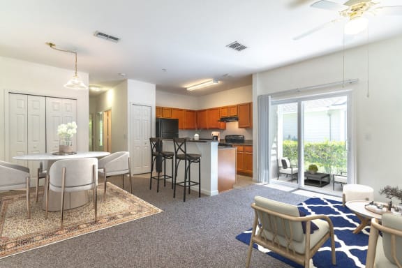 a living room with a kitchen and a table and chairs