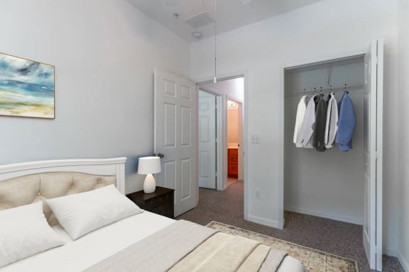 a bedroom with a bed and a closet with clothes hanging on the wall