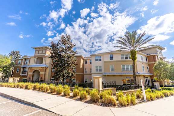 A large apartment complex with a palm tree in front.