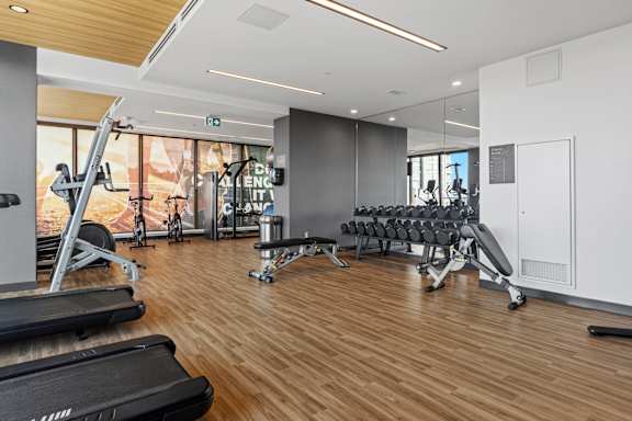 A gym with treadmills, weights, and exercise equipment.