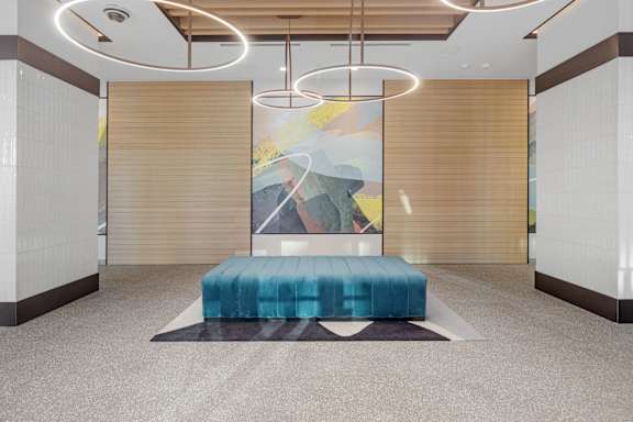 A modern room with a blue bench and a painting on the wall.