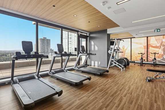 A gym with treadmills, weights, and exercise equipment.