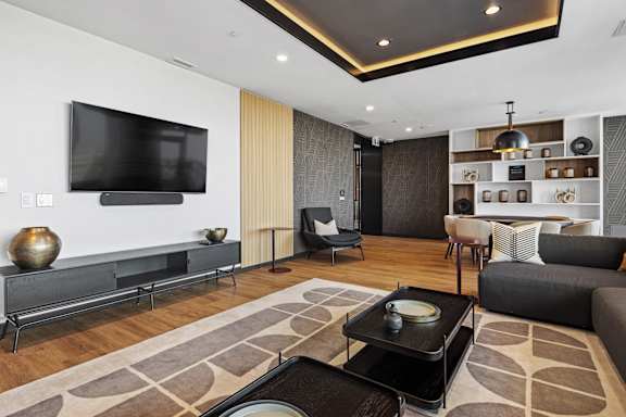 A modern living room with a flat screen TV mounted on the wall.
