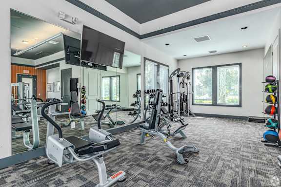 A spacious gym with a variety of equipment including treadmills, weights, and exercise machines.
