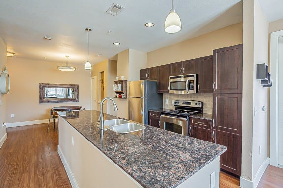 a kitchen with granite counter tops and stainless steel appliances at The Landings at Brooks City-Base, San Antonio