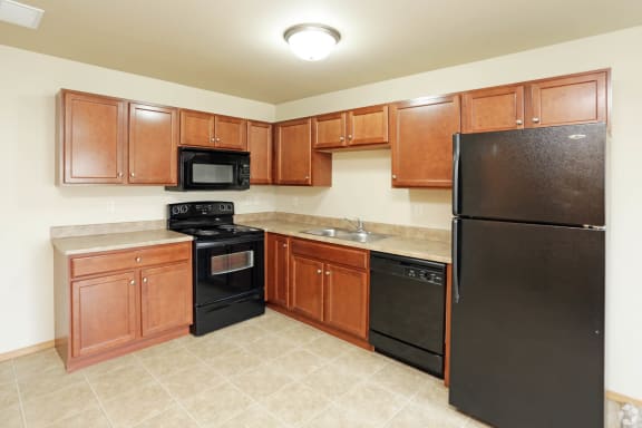 a kitchen with wood cabinets and black appliances