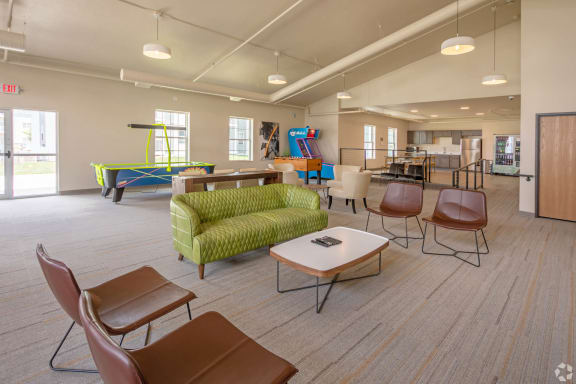 a lounge area with chairs tables and a ping pong table