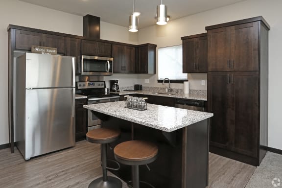 a kitchen with dark wood cabinets and a granite counter top
