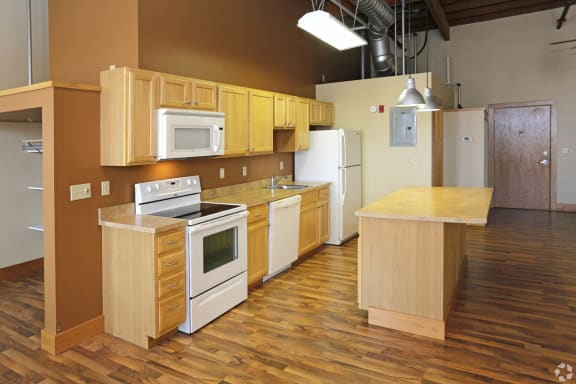 an open kitchen with white appliances and wooden cabinets