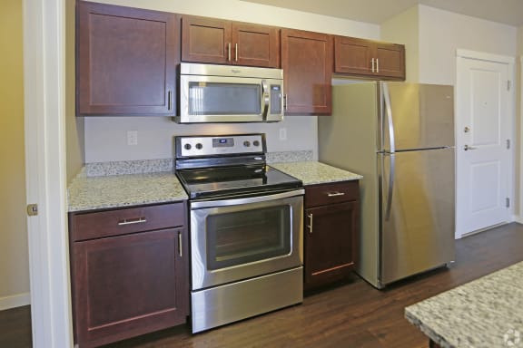 a kitchen with wooden cabinets and stainless steel appliances