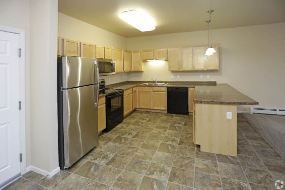 a large kitchen with stainless steel appliances and wooden cabinets