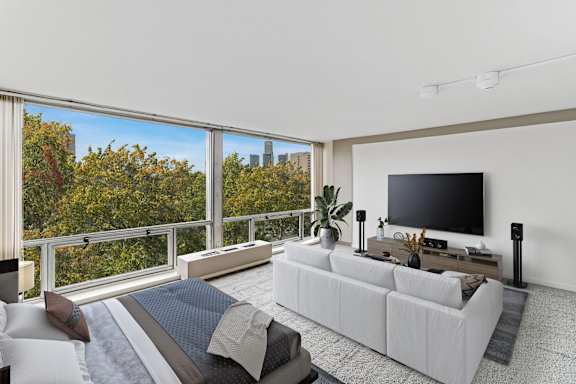 A modern living room with a large window overlooking a city skyline.