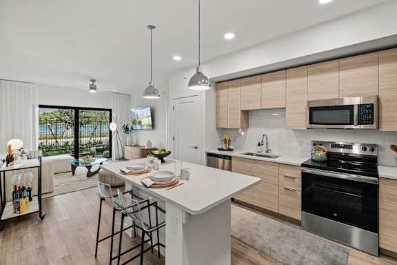 a kitchen with a large island and a stove and a sink at Altis Grand Kendall, Florida, 33186