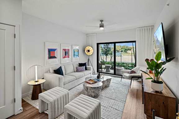 a living room with white furniture and a large window at Altis Grand Kendall, Florida
